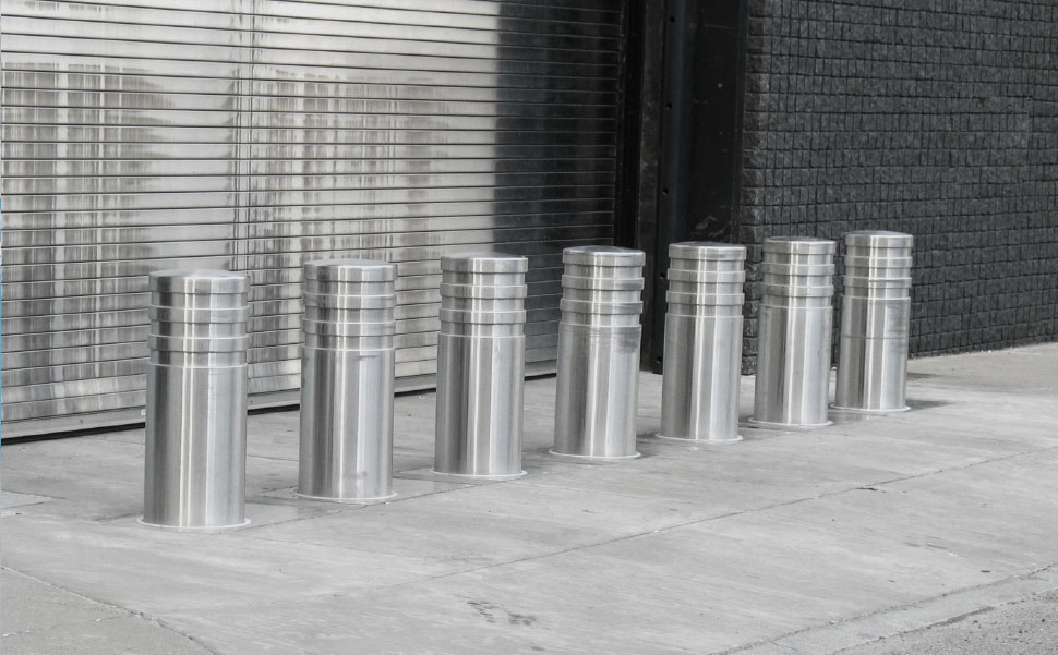 A group of stainless steel poles in front of a building.