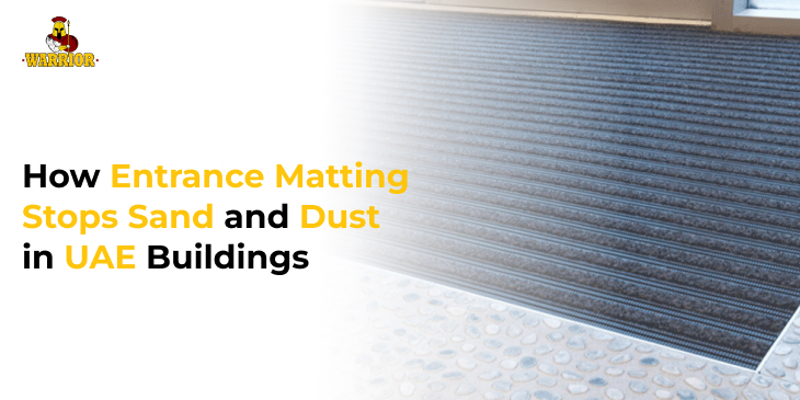 Recessed ridged aluminium entrance matting at a building doorway with sand and dust blowing across it