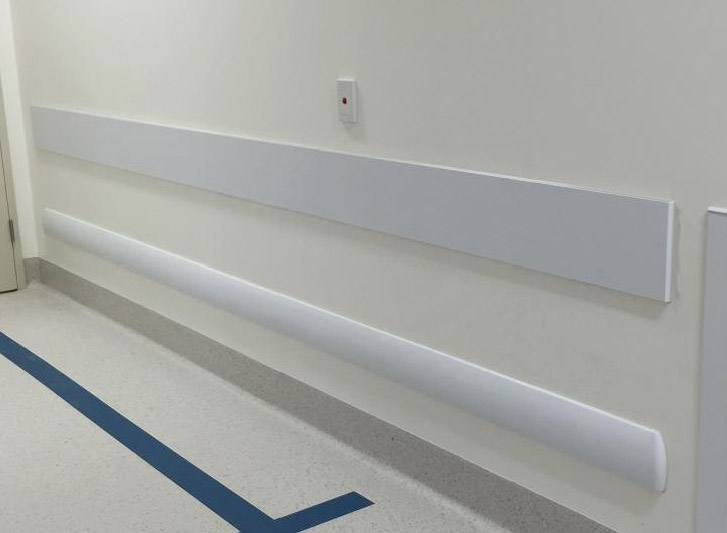 A hospital room with PVC wall guards protecting the white wall.