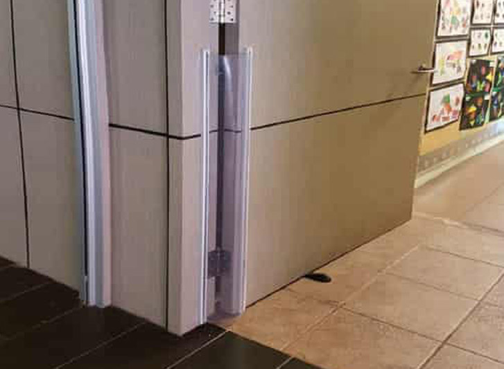 A door with a foam corner and wall guard attached to it.