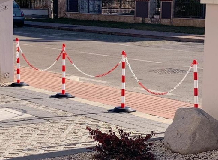 A red and white barricade, used for trailer support on the side of a street.