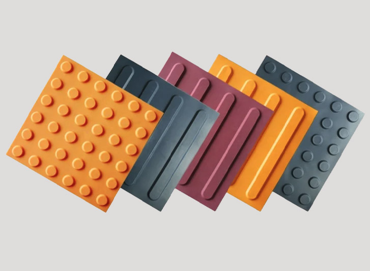 A set of different colored rubber mats on a white background, enhanced with tactile tiles.