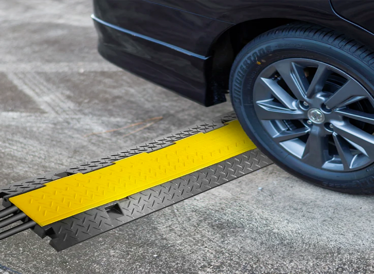 A black car with a yellow ramp and convex traffic mirror attached to it.