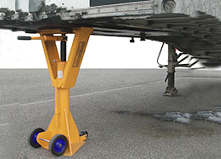 An image of a trailer with a jack attached to it, supported by dock bumpers.