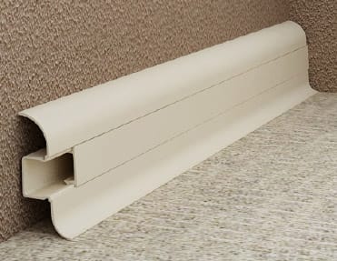 A white plastic rail on a carpeted floor, with pvc skirting.
