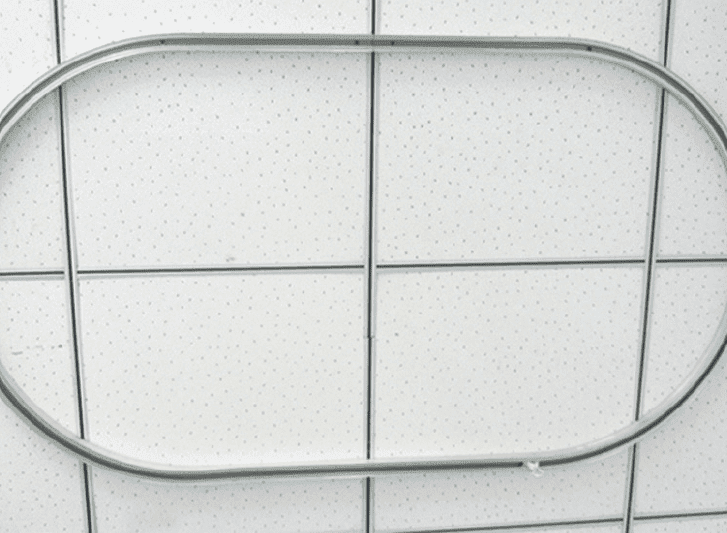 A metal shower ring on a tiled wall.