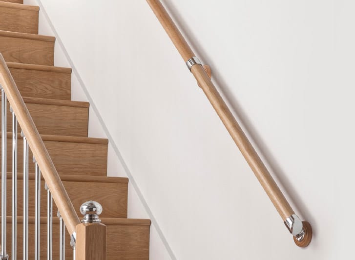 A wooden stair rail with a metal handrail and Wood Corner Guards.